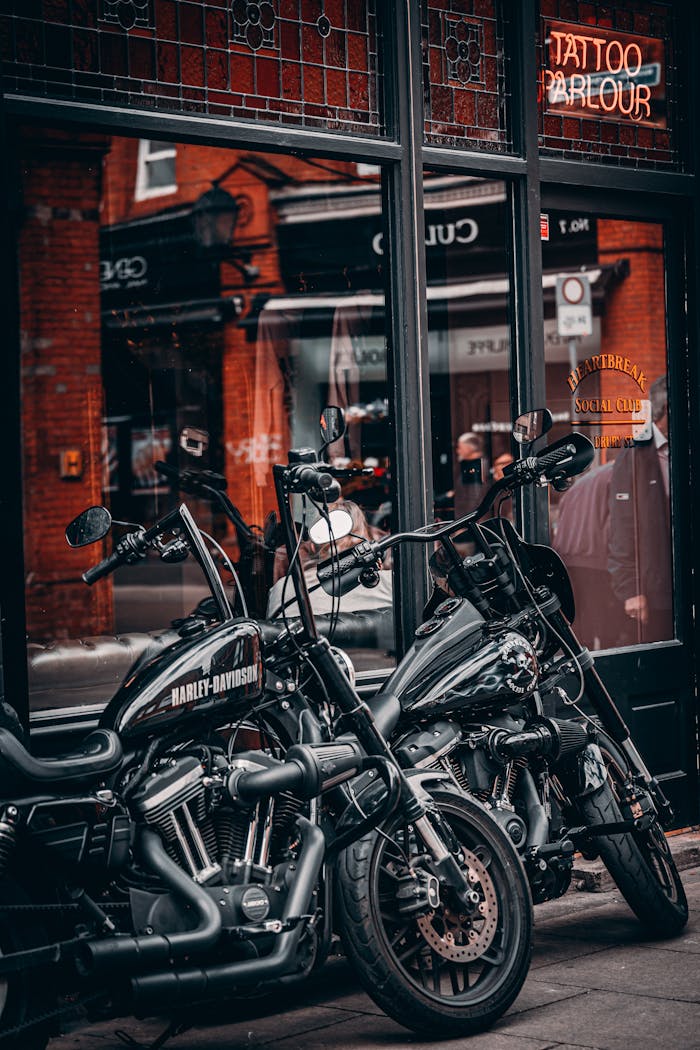 Two Harley Davidson motorbikes parked outside a tattoo parlour in Dublin's urban setting.